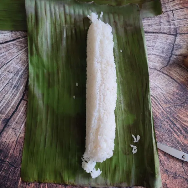 Tata nasi putih diatas daun, betuk memanjang seperti di foto.