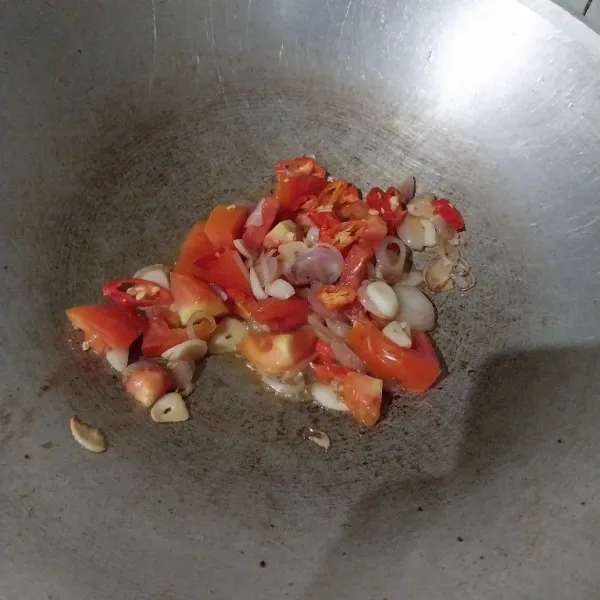 Tumis bawang merah, bawang putih, tomat, dan cabai rawit sampai harum dan agak layu.
