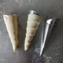 Lilitkan puff pastry ke cetakan, lakukan hingga habis dan tata pada loyang yang sudah di alasi kertas roti anti lengket.