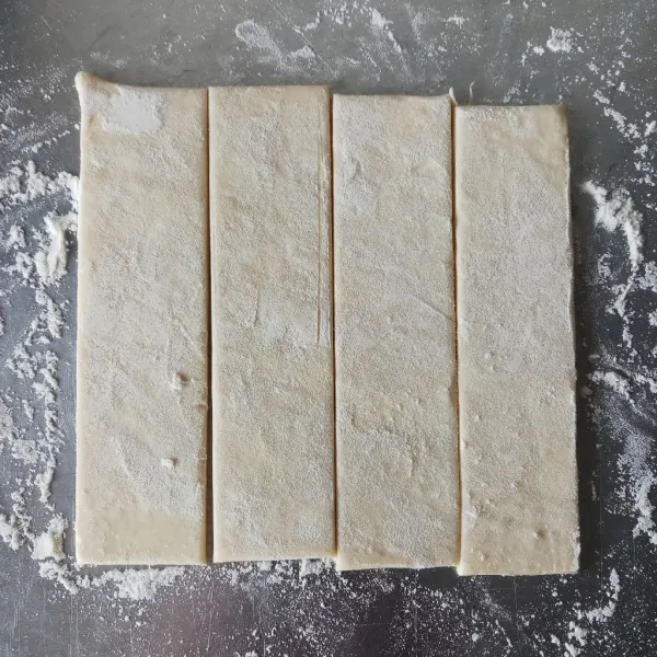 Siapkan puff pastry instan yang sudah lunak (tidak beku), kemudian potong menjadi 4 bagian. Gilas hingga memanjang.