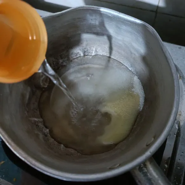 Campurkan ke dalam panci gula, agar-agar bubuk dan kental manis. Kemudian tuang sisa air.