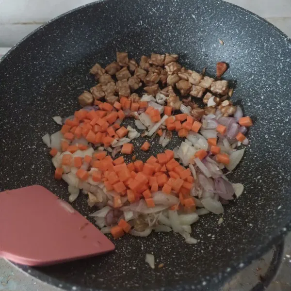 Masukkan bawang putih, bawang bombai dan wortel lalu aduk rata. Masak hingga layu.