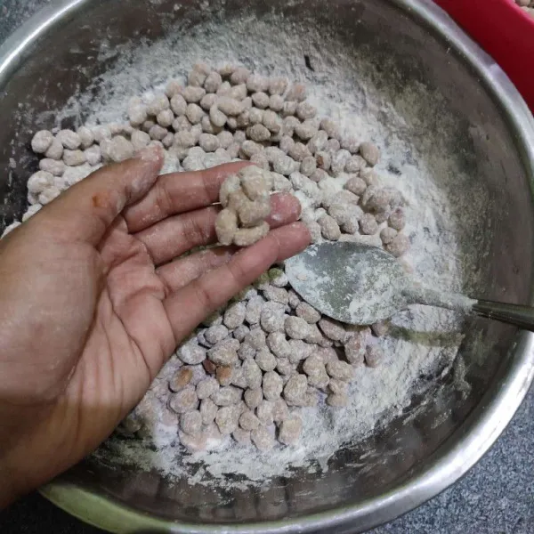 Pisahkan jika ada kacang yang menggumpal, kemudian aduk kembali agar kacang terbalut tepung.