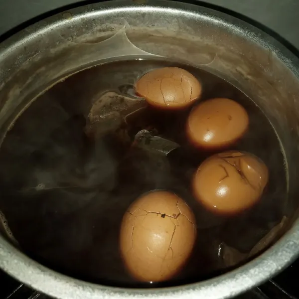 Kembalikan telur ke air rebusannya, nyalakan api kembali dan masak sampai cairan tinggal setengahnya dan telur kecokelatan. Matikan api dan biarkan sampai suhu ruang. Siap disajikan.