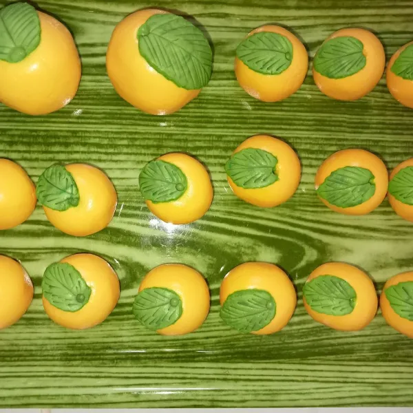 Bulatkan adonan orange menyerupai jeruk, lalu pipihkan adonan hijau dan cetak/ bentuk menyerupai daun, letakkan di atas adonan jeruk, tambahkan lubang diantara adonan daun dan jeruknya.