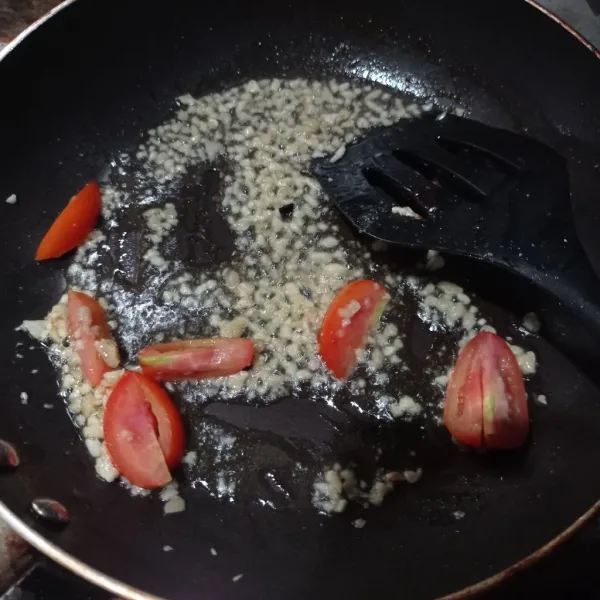 Tumis bawang putih dan tomat sampai matang.