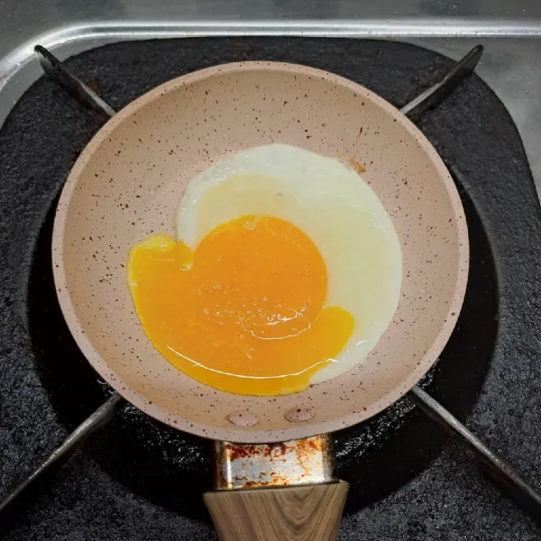 Bikin telur ceplok, taburi sedikit garam. Masak telur sampai matang. Angkat dan sisihkan.