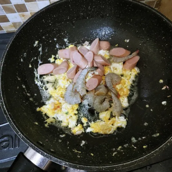 Masukan telur, aduk cepat lalu masukan sosis dan udang masak sampai terus diaduk agar matang merata.