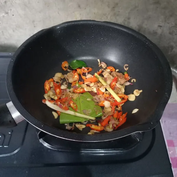 Tumis irisan bawang sampai harum. Masukkan cabai dan bumbu aromatik. Tumis lagi sampai layu.