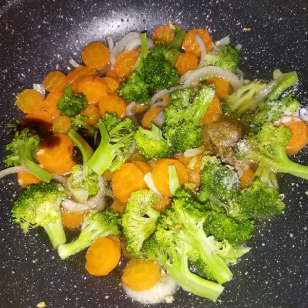 Masukkan wortel, brokoli, 150 ml air, saus tiram, kecap asin, lada bubuk dan gula pasir, aduk rata, masak hingga kuahnya mendidih.