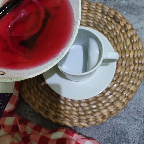 Tuang teh kulit buah naga ke dalam gelas saji.