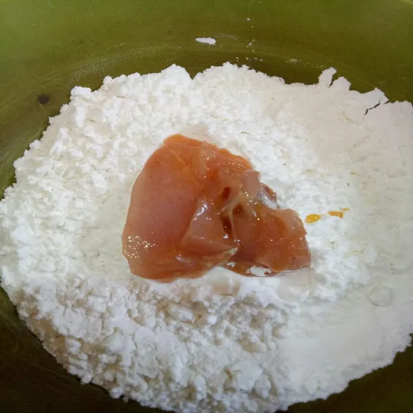 Letakan ayam di atas adonan tepung,  lalu balur hingga rata.