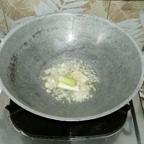 Tumis bawang putih dan daun bawang prei bagian putihnya sampai harum.