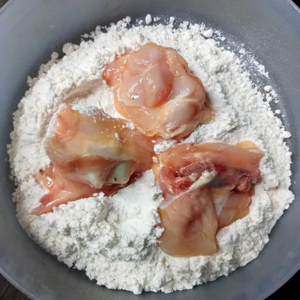 Baluri ayam dengan tepung sampai merata.