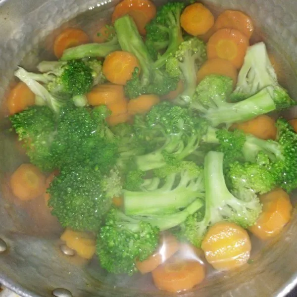 Didihkan air secukupnya, lalu rebus wortel selama 2 menit, lalu masukkan brokoli, rebus sekitar 1 menit, angkat lalu tiriskan.