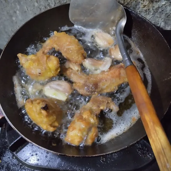 Goreng dalam minyak panas hingga ayam hampir matang, lalu masukkan bawang putih. Angkat bersama dengan ayam saat sudah matang. Tiriskan.