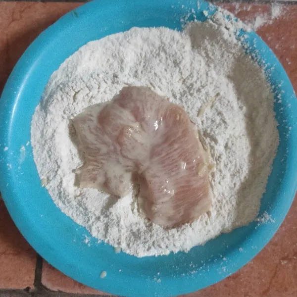 Balur ayam yang sudah dicelupkan ke dalam tepung kering.