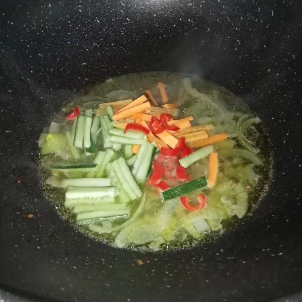 Tuang air dan setelah mendidih masukkan timun, wortel dan cabai.