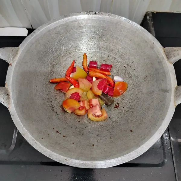 Goreng cabai besar, cabai rawit, bawang merah, bawang putih, tomat dan terasi hingga layu.