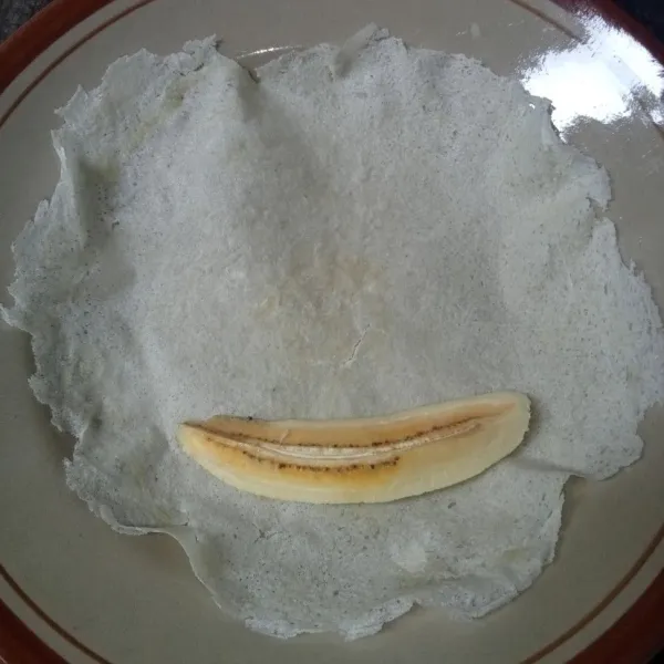 Letakkan sepotong pisang di atas kulit lumpia.