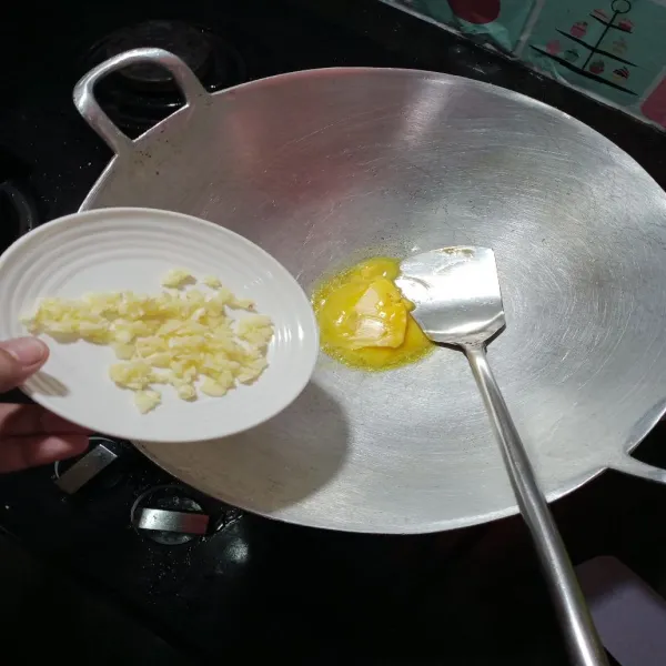 Panaskan mentega dalam wajan, lalu tumis bawang putih hingga harum