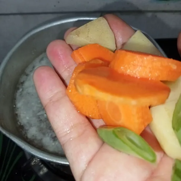 Masukkan wortel, buncis dan kentang, masak sampai setengah matang.
