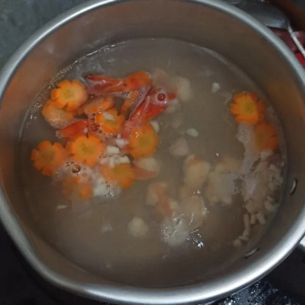 Masukkan bawang putih, wortel dan udang. Tunggu wortel setengah matang.