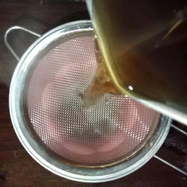 Saring teh ke dalam gelas.