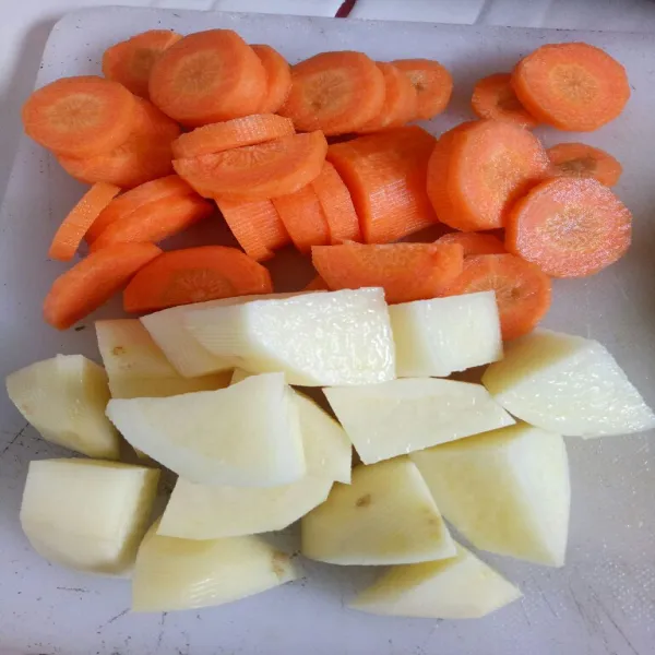 Kupas kentang dan wortel, lalu potong sesuai selera.