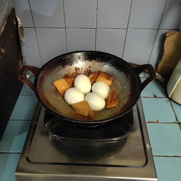 Masukkan telur rebus dan tahu goreng.
