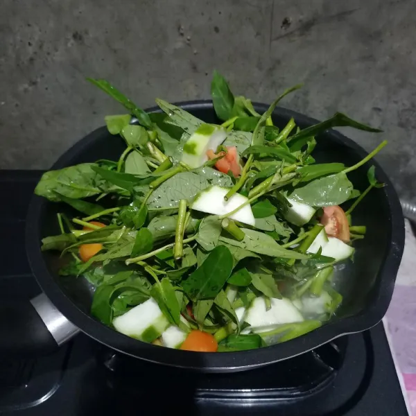 Masukkan kangkung, gambas, tomat, dan air.