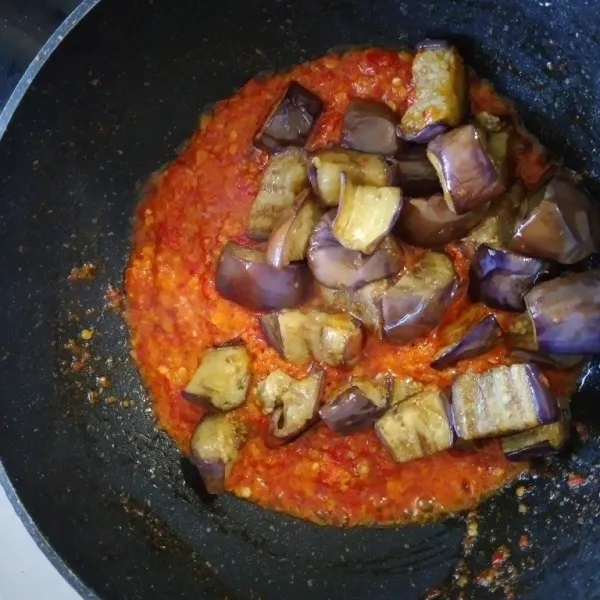 Masukkan terong, penyedap rasa, garam dan gula. Aduk merata, koreksi rasa.