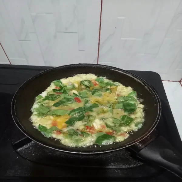 Panaskan minyak di teflon lalu masak telur hingga matang di sisi bawahnya.