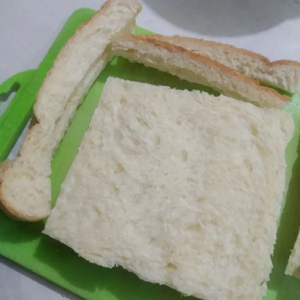 Karena adanya roti tawar dengan pinggiran, maka potong dan buang pinggiran roti, sisihkan.