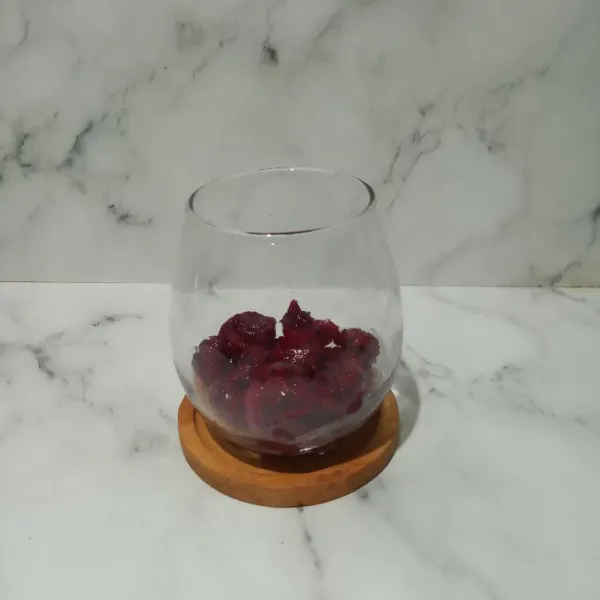 Taruh irisan buah naga ke dalam gelas saji.