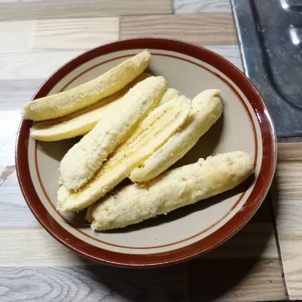 Kupas pisang kemudian belah menjadi 4 bagian.