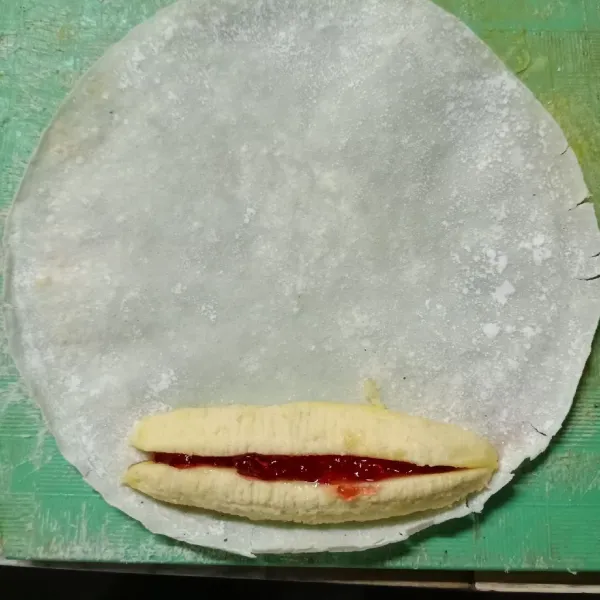 Ambil 1 lembar kulit lumpia. Beri 1 potong pisang kemudian beri selai secukupnya lalu 1 potong pisang lagi.