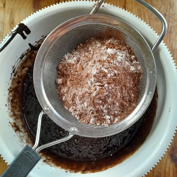 Masukkan tepung terigu, coklat bubuk, kopi instan dan krimer bubuk, sambil diayak. Mixer kembali dengan kecepat rendah, asal rata.