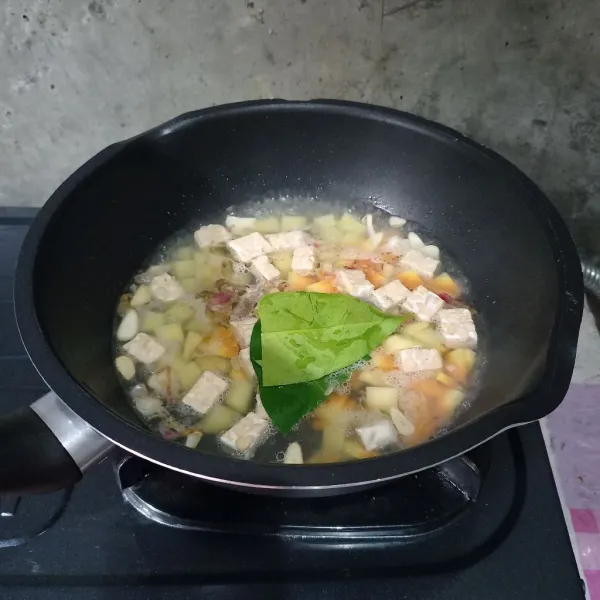 Masukkan air, wortel, kentang, tempe dan daun salam.