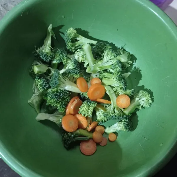 Buang bonggol bawah brokoli lalu potong tiap kuntumnya, iris juga wortel, cuci bersih tiriskan (bisa juga rendam dengan garam).