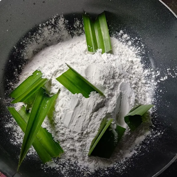 Masukkan tepung beras dan daun pandan ke wajan.