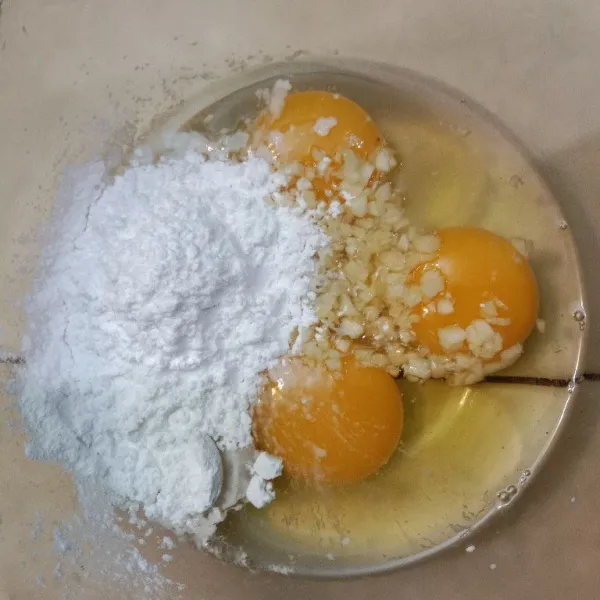 Pecahkan 3 butir telur kemudian campurkan dengan tepung tapioka, tepung crispy dan bawang putih cincang, kocok sampai rata.