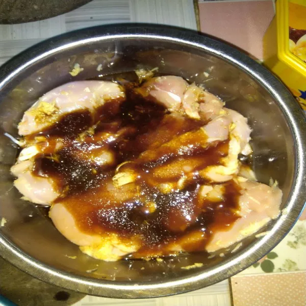 Dalam wadah, campur ayam dengan jahe, bawang putih parut, kecap asin, saus tiram, minyak wijen dan gula pasir. Aduk rata.