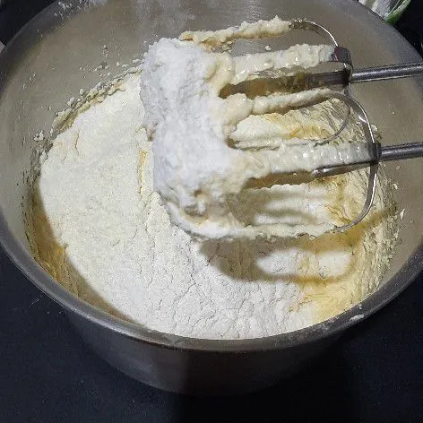 Kemudian masukkan tepung dan susu bubuk, sambil diayak mix perlahan hingga rata, lanjut aduk rata menggunakan spatula.