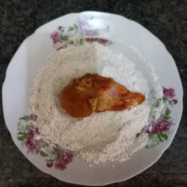 Ciprati ayam dengan sedikit air, lalu gulingkan pada adonan tepung, lakukan sekali lagi tahap ini, pastikan tepung menempel pada ayam.