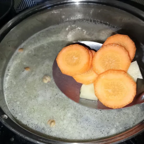 Tuang air secukupnya, lalu masukkan kentang dan wortel. Masak sampai sop matang.