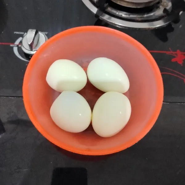 Rebus telur hingga matang, lalu kupas.