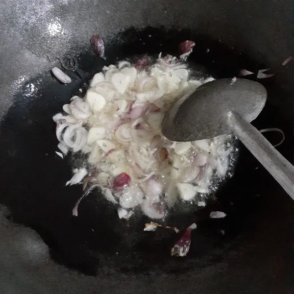 Panaskan minyak sayur dengan api sedang, tumis bawang merah hingga layu. Masukkan bawang putih, tumis hingga layu.