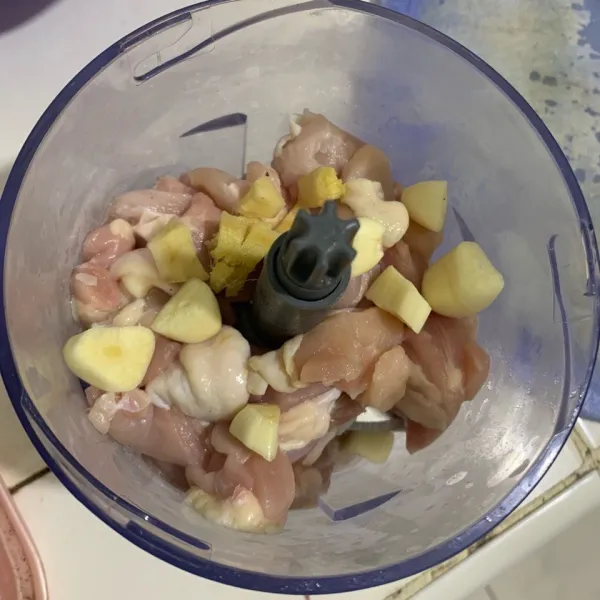 Potong-potong ayam lalu haluskan ayam bersama dengan bawang putih dan jahe hingga tercampur rata.