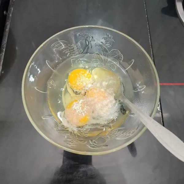 Pecahkan telur dalam mangkuk. Lalu tambahkan merica bubuk, kaldu bubuk, dan garam. Aduk hingga tercampur rata.